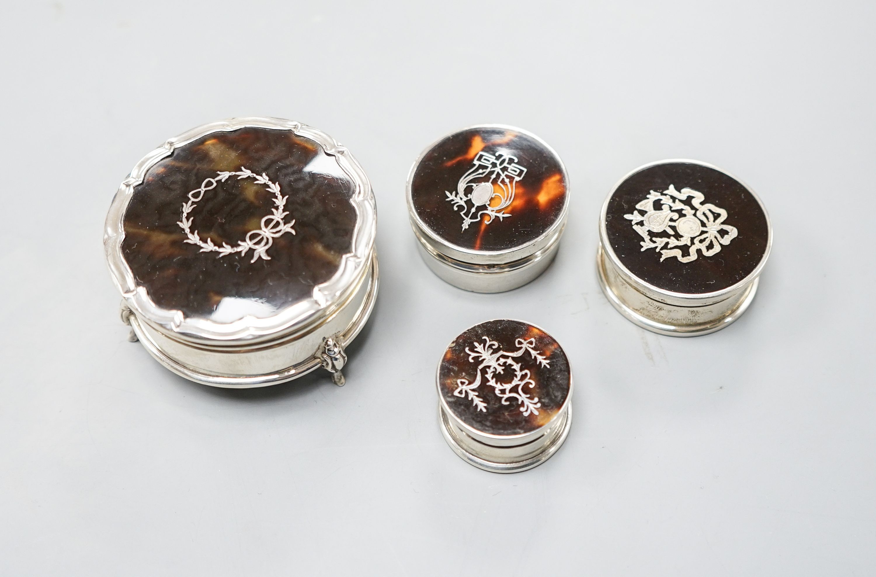 A George V silver and tortoiseshell pique circular trinket box, Birmingham, 1923, 61mm and three other similar smaller boxes and covers.